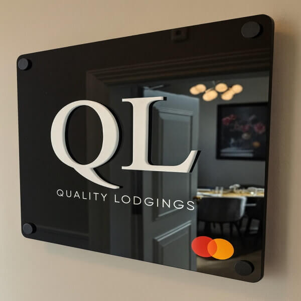 Acryl naambord met bedrijfslogo aan de muur bevestigd met afstandhouders