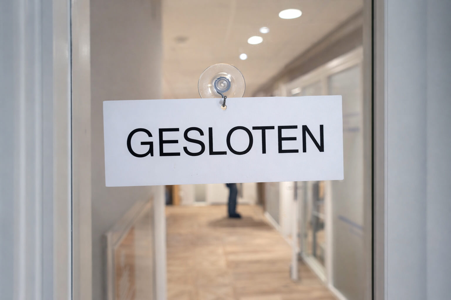 Gesloten-bordje op glazen deur van kantoorruimte